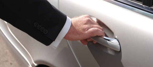 Chauffeur öffnet Limousinentür an der Haustür